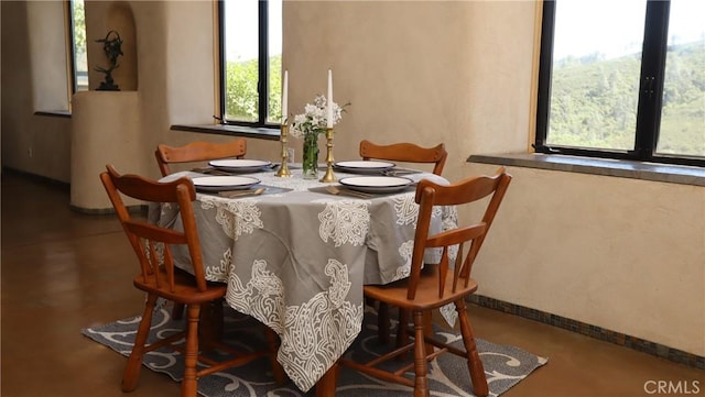 dining space featuring baseboards and concrete floors