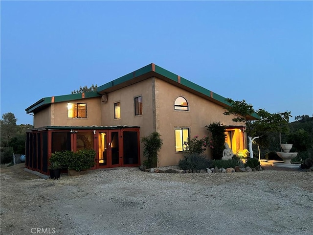 view of front of house with stucco siding and french doors