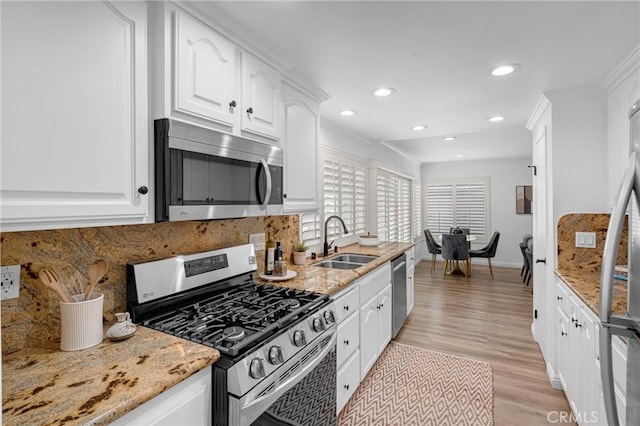 kitchen featuring a sink, appliances with stainless steel finishes, backsplash, and white cabinets