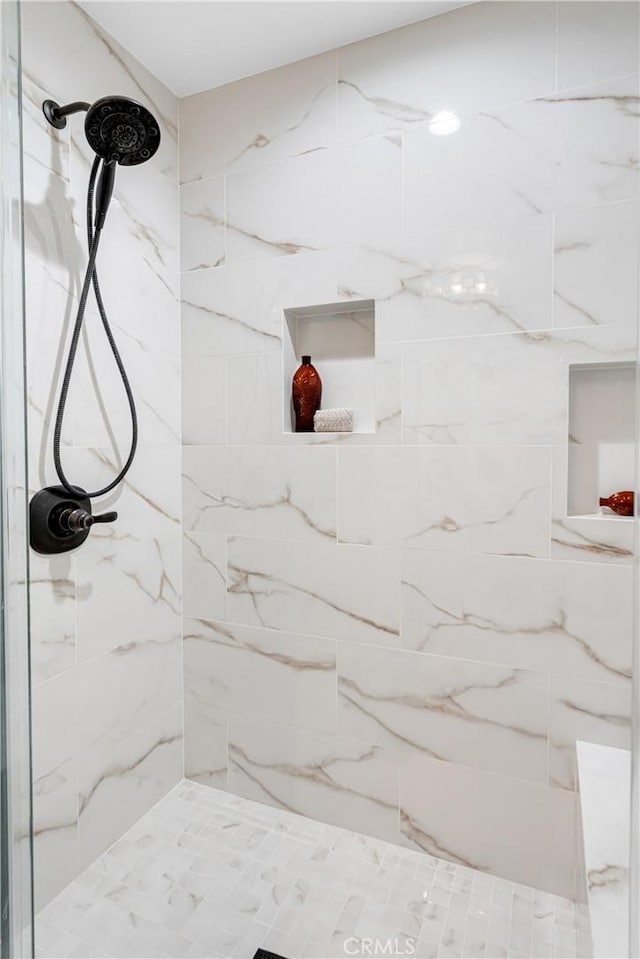 bathroom featuring a marble finish shower