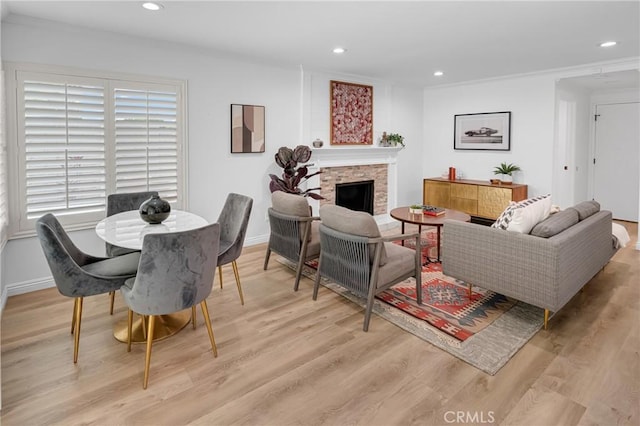 living room featuring recessed lighting, light wood-type flooring, and a stone fireplace