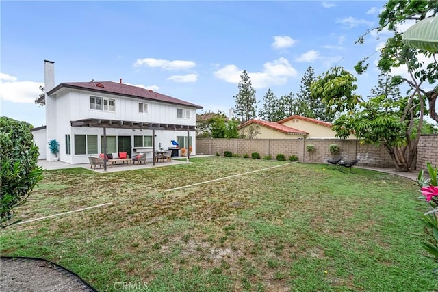 rear view of property featuring a pergola, a fenced backyard, a chimney, a patio, and a yard