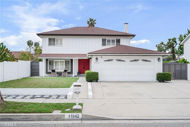 traditional-style home featuring fence, a shingled roof, a garage, a front yard, and concrete driveway