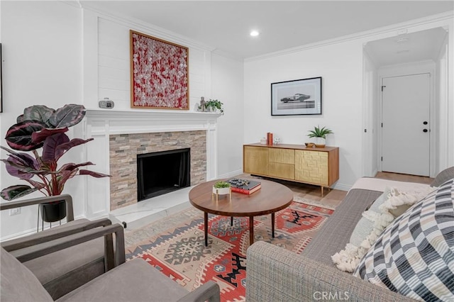 living area with baseboards, ornamental molding, recessed lighting, and a stone fireplace