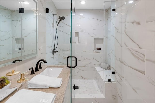 bathroom featuring a marble finish shower, vanity, and recessed lighting