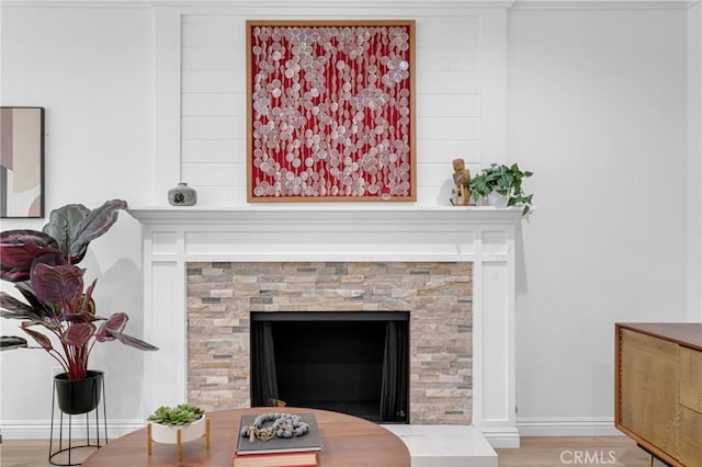 interior details with baseboards, a fireplace, and wood finished floors