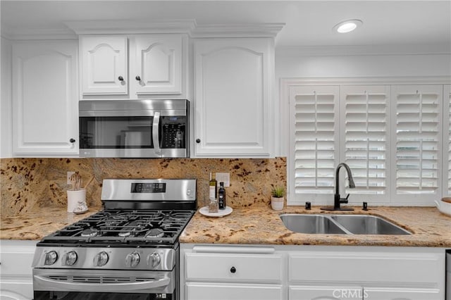 kitchen with stainless steel appliances, white cabinetry, and a sink