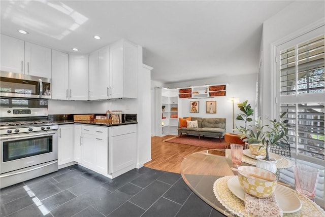 19801 Meadow Ridge Dr Unit 35, Trabuco Canyon, CA 92679 - kitchen with dark countertops, open floor plan, dark tile patterned floors, white cabinetry, and stainless steel appliances