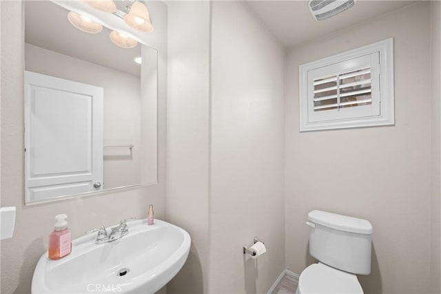 bathroom featuring toilet, visible vents, and a sink
