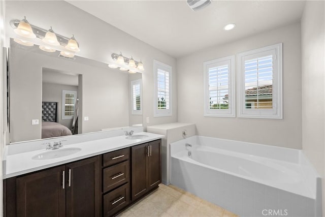full bathroom with connected bathroom, double vanity, a sink, and a garden tub