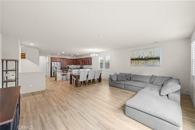 living room with light wood-style floors, recessed lighting, and a chandelier