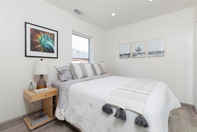 bedroom with recessed lighting, visible vents, and wood finished floors