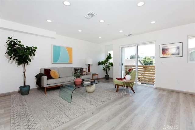 living room with recessed lighting, baseboards, visible vents, and light wood finished floors