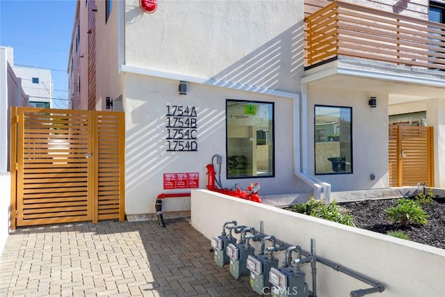 entrance to property featuring stucco siding and a balcony