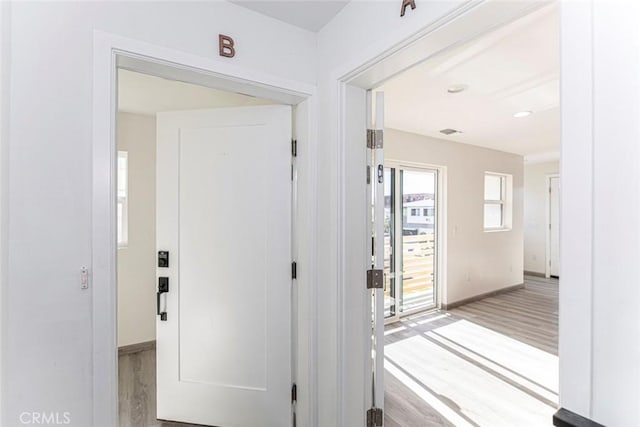 doorway with baseboards and light wood finished floors