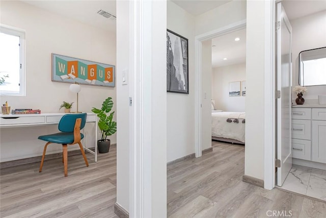 hall with visible vents, recessed lighting, light wood-style floors, and baseboards