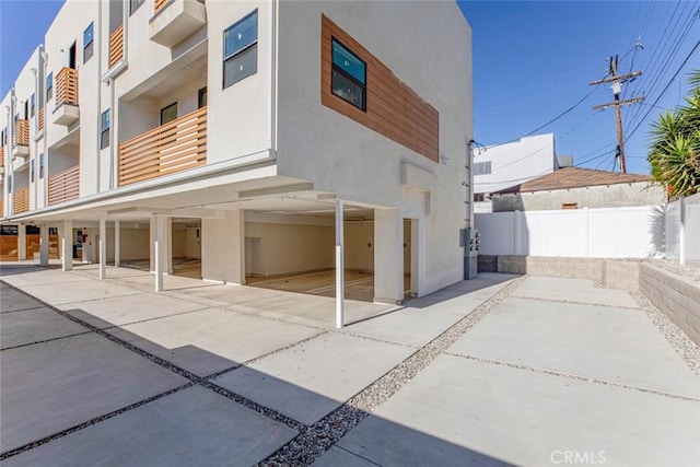 exterior space featuring a patio area, stucco siding, and fence