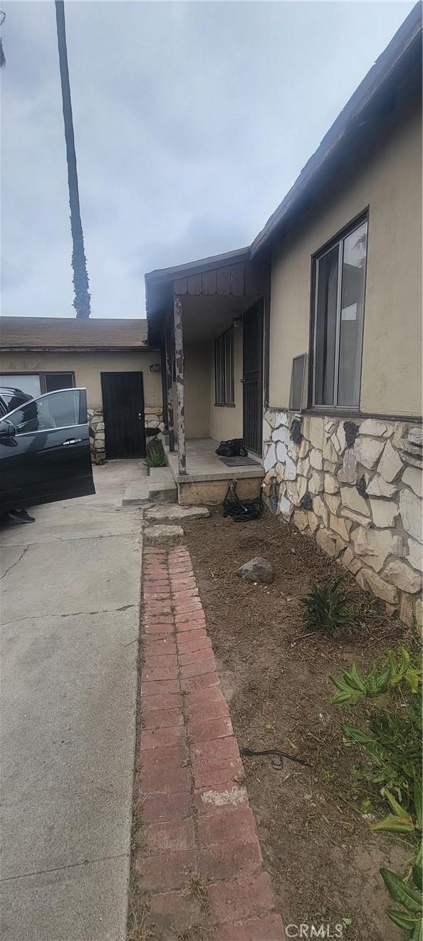 exterior space with stucco siding and stone siding