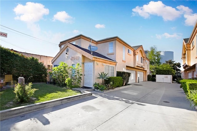 view of front of property featuring an attached garage, driveway, and stucco siding