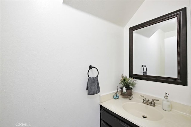 bathroom featuring vaulted ceiling and vanity