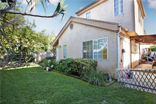 view of side of property featuring stucco siding and a patio