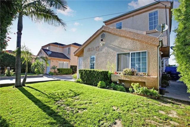 view of front of home featuring stucco siding and a front yard