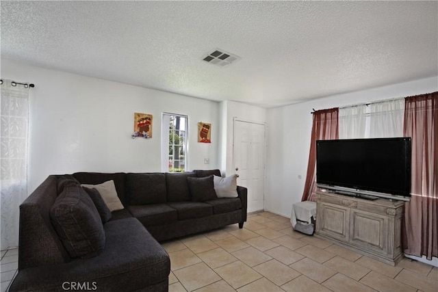 living area with a textured ceiling and light tile patterned floors