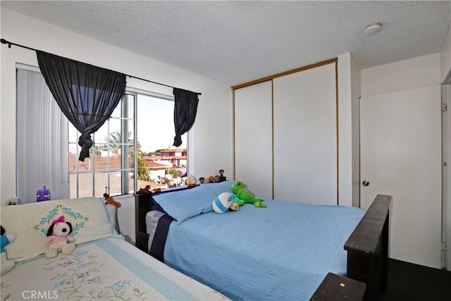 bedroom featuring a textured ceiling and a closet