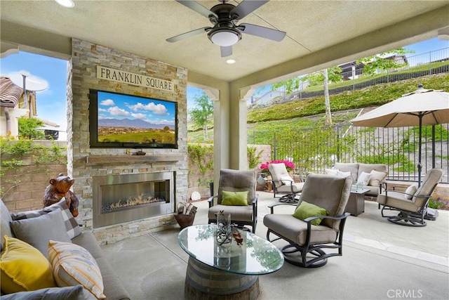 exterior space with ceiling fan, an outdoor living space with a fireplace, and fence