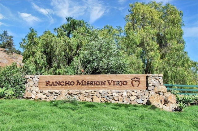 community sign featuring a lawn and fence