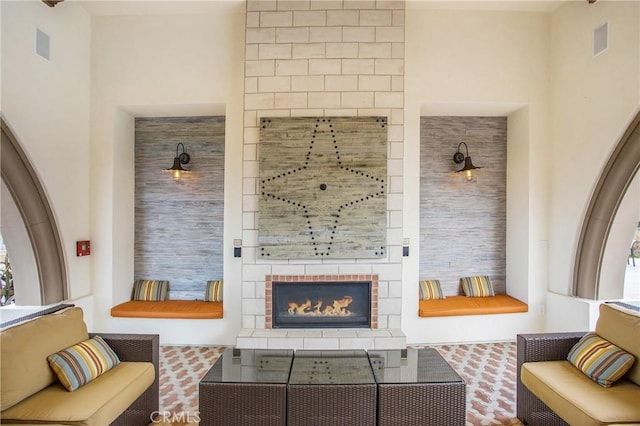 living area featuring visible vents and a tile fireplace