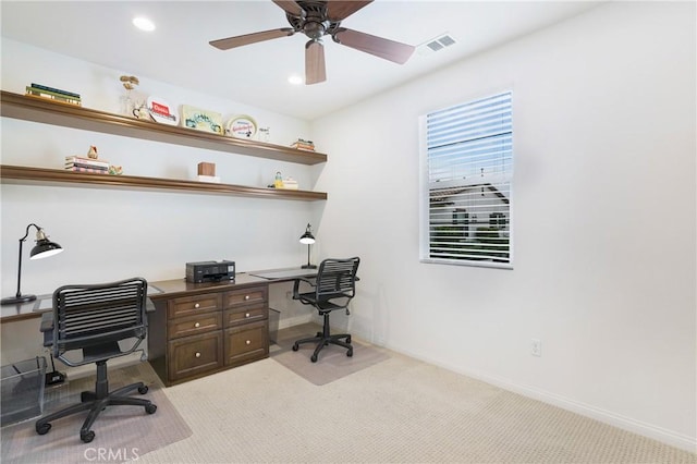 home office with baseboards, visible vents, a ceiling fan, and light colored carpet