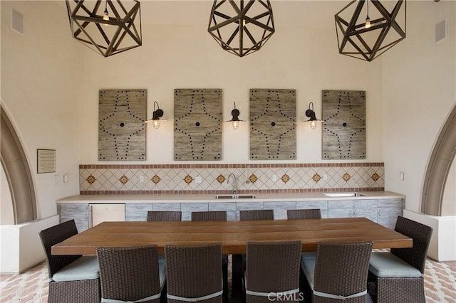 interior space featuring decorative light fixtures, a sink, and tasteful backsplash