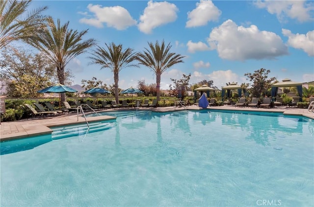 community pool with a gazebo and a patio area