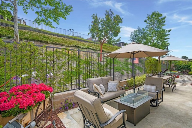 view of patio with fence and an outdoor living space with a fire pit