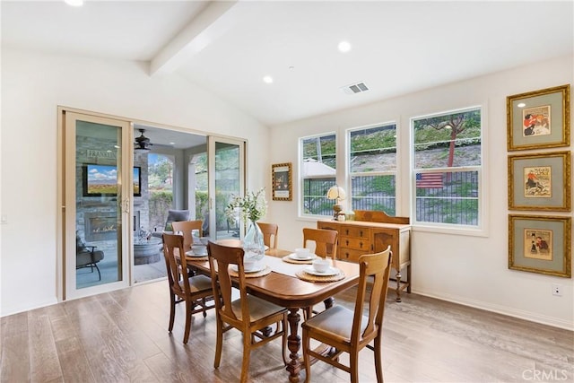 dining room featuring ceiling fan, visible vents, lofted ceiling with beams, and wood finished floors