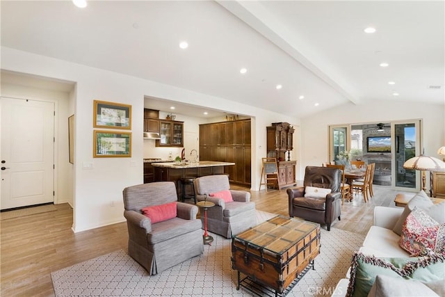 living room with recessed lighting, baseboards, vaulted ceiling with beams, and light wood-style flooring