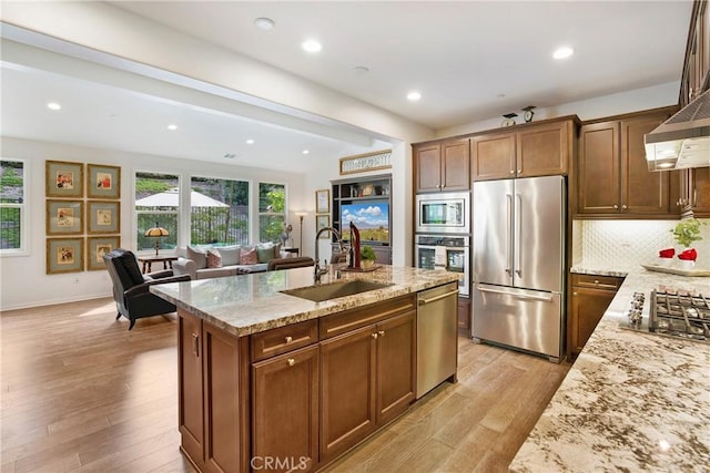 kitchen with plenty of natural light, a sink, light wood-style flooring, and stainless steel appliances