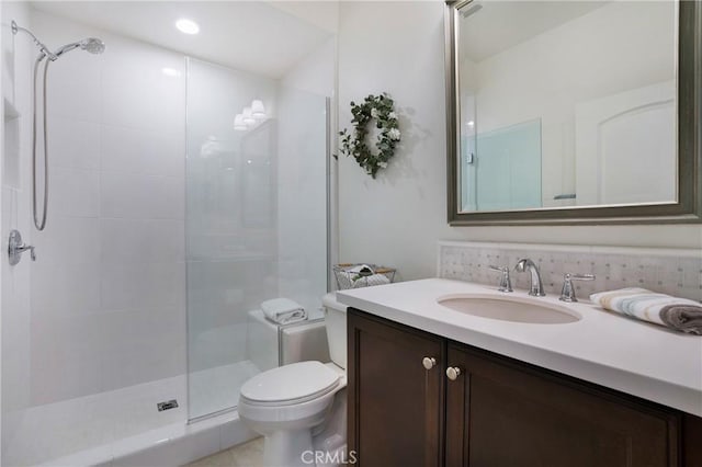 full bathroom featuring recessed lighting, vanity, a tile shower, and toilet