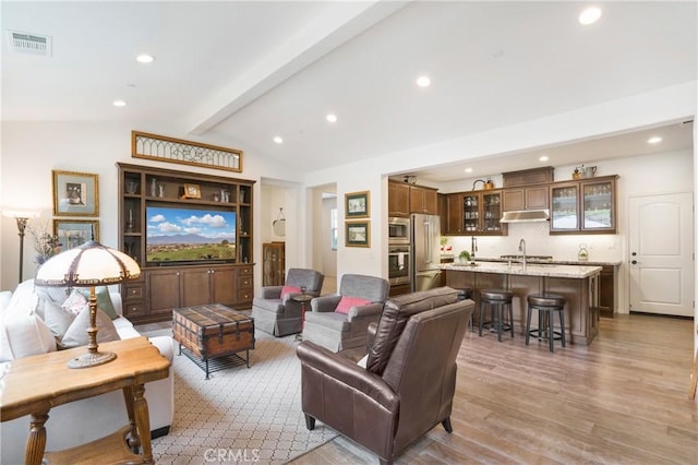 living room featuring lofted ceiling with beams, recessed lighting, wood finished floors, and visible vents