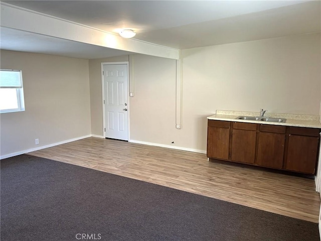 interior space with baseboards, a sink, and wood finished floors