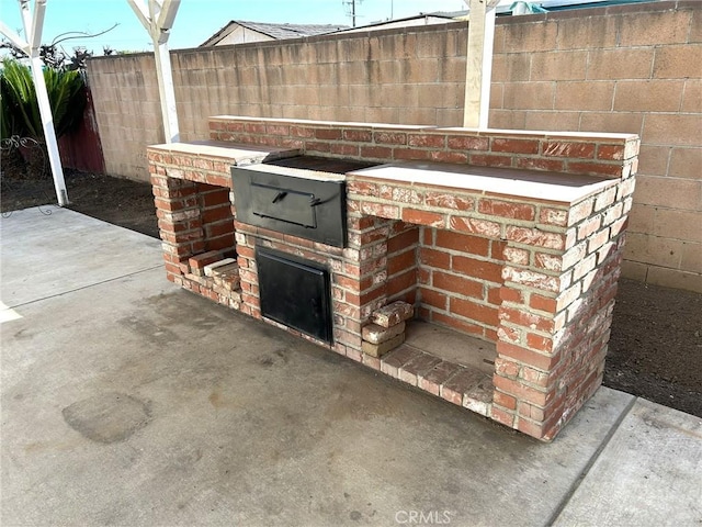 view of patio featuring fence and an outdoor kitchen