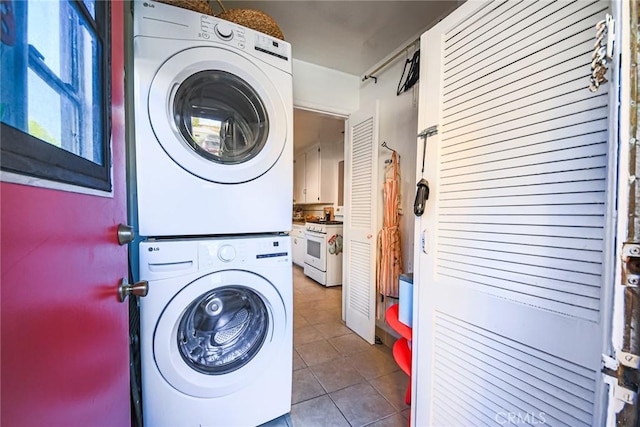 laundry room featuring stacked washer and dryer, tile patterned floors, and laundry area