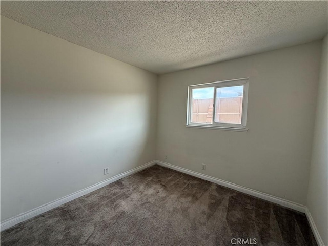 carpeted empty room with baseboards and a textured ceiling