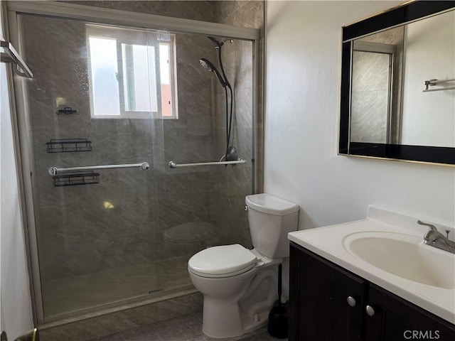 full bathroom featuring vanity, a stall shower, and toilet