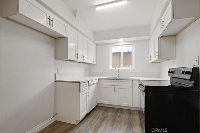 9867 Cornwall Dr, Huntington Beach, CA 92646 - kitchen featuring electric range, a sink, dishwasher, light wood-style flooring, and white cabinetry