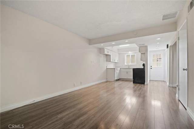 9867 Cornwall Dr, Huntington Beach, CA 92646 - unfurnished living room with baseboards, wood finished floors, recessed lighting, and a sink
