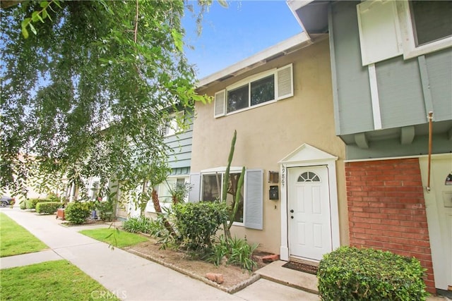 9867 Cornwall Dr, Huntington Beach, CA 92646 - view of exterior entry featuring brick siding and stucco siding