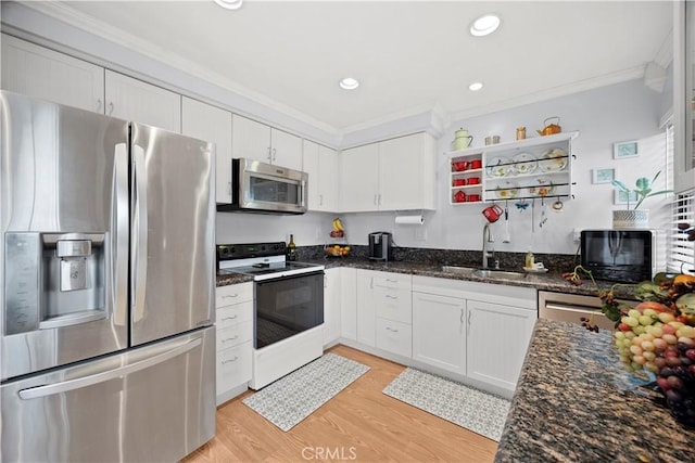 kitchen with white cabinets, appliances with stainless steel finishes, ornamental molding, and a sink