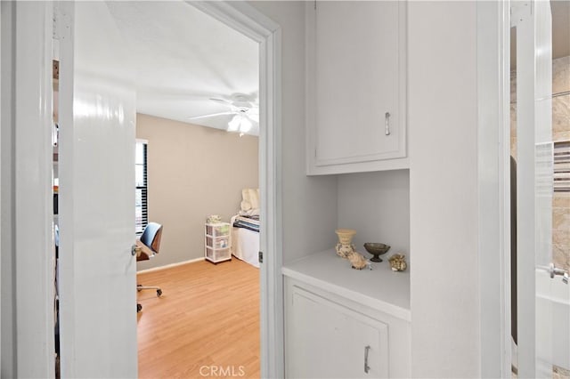 hallway featuring baseboards and light wood-style flooring